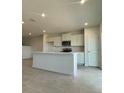 Bright kitchen with white cabinets, stainless steel microwave, and a large kitchen island at 1904 Diamond Head Cir, Lake Hamilton, FL 33851