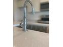 Close up of the kitchen sink, featuring modern faucet fixtures and a quartz countertop at 1904 Diamond Head Cir, Lake Hamilton, FL 33851