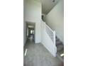 Bright entryway featuring tile floors, staircase with white railing and neutral color palette at 1908 Diamond Head Cir, Lake Hamilton, FL 33851