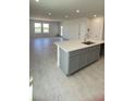 Open-concept kitchen featuring an island with light countertops and modern grey cabinets at 1908 Diamond Head Cir, Lake Hamilton, FL 33851