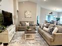 Comfortable living room with vaulted ceilings, neutral decor, and wood-look floors at 2000 Golden Beak Dr, Eagle Lake, FL 33839