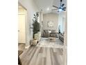 Bright living room featuring vaulted ceilings, neutral decor, and wood-look floors at 2000 Golden Beak Dr, Eagle Lake, FL 33839