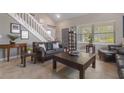 Bright living area with tile flooring, a comfortable sofa, and a staircase in the background at 3001 Little Cypress Cv, Winter Park, FL 32792