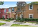 Inviting townhome featuring a colorful facade, well-maintained landscaping, and inviting entryway at 3064 Yellow Lantana Ln, Kissimmee, FL 34747