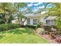 A picturesque view of the home's side exterior, highlighting the lush greenery, manicured lawn, and architectural details at 3332 Stonewood Ct, Orlando, FL 32806