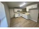 Bright kitchen featuring white cabinets, new flooring and modern appliances at 403 Short Dr, Poinciana, FL 34759