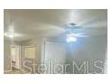 Spacious living room featuring new wood-look flooring and a ceiling fan at 403 Short Dr, Poinciana, FL 34759