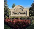 Elegant 'Lake Lincoln' community entrance sign with lush landscaping and vibrant flowers, creating a welcoming atmosphere at 4066 Serene Water Ave, Eustis, FL 32736