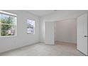 Bright bedroom with tile flooring, large windows and closet with white door at 451 Shadow Gorge Way, Eustis, FL 32736