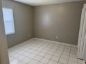 This bedroom has tile flooring, gray walls, and a single window at 4617 Frisco Cir, Orlando, FL 32808