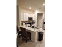 Kitchen with white cabinets, stainless steel appliances, and a quartz countertop island with seating at 4762 Sparkling Shell Ave, Kissimmee, FL 34746