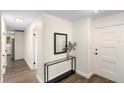 Bright hallway featuring neutral paint, modern console table, and durable flooring at 577 Compton Ct, Deland, FL 32724