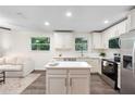 Bright kitchen features white cabinets, stainless steel appliances, and a functional center island at 577 Compton Ct, Deland, FL 32724