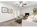Cozy living room with white brick fireplace, ceiling fan, and French doors leading to the outside at 577 Compton Ct, Deland, FL 32724