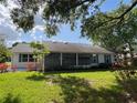 Lush backyard featuring a screened lanai, complemented by the beauty of mature trees at 6042 Wade St, Leesburg, FL 34748