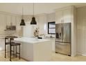 Modern kitchen boasts an island with seating, stainless steel appliances, and white cabinets at 6168 Sw 154Th St, Ocala, FL 34473
