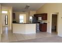 Bright kitchen featuring tiled floors, stainless appliances and a breakfast bar overlooking the living area at 697 Winding Lake Dr, Clermont, FL 34711