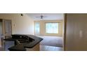 View of the Living Room from the kitchen with neutral colors, lots of light and carpeted floors at 697 Winding Lake Dr, Clermont, FL 34711