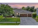 Charming single-story home featuring an attached 3-car garage, manicured lawn, and inviting front entrance at 721 Lake Cove Pointe Cir, Winter Garden, FL 34787