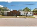 View of a single story home with a wood and white exterior, partially fenced in, located on a residential street at 730 W Swoope Ave, Winter Park, FL 32789