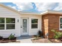 Close up of the exterior featuring modern wood siding, a secured glass door, and a manicured front lawn at 730 W Swoope Ave, Winter Park, FL 32789