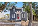 Charming two-story home with gray siding, a red door, and a well-manicured front yard at 821 E Lemon Ave, Eustis, FL 32726