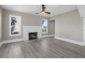 Bright living room with hardwood floors, white brick fireplace, and large windows at 821 E Lemon Ave, Eustis, FL 32726