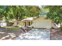 Inviting single-story home with a charming facade, mature trees, and a well-kept lawn at 8316 Granada Blvd, Orlando, FL 32836