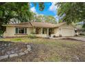 Single-story home with a well-manicured lawn and mature trees, offering both curb appeal and shade at 8316 Granada Blvd, Orlando, FL 32836