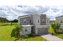 Stylish two-story home featuring modern design, stone accents, and beautiful green lawn at 901 Ocean Course Ave, Davenport, FL 33896