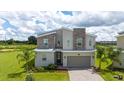 Stylish two-story home featuring modern design, stone accents, and beautiful green lawn at 901 Ocean Course Ave, Davenport, FL 33896
