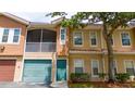 Inviting exterior of a two-story townhome with a private screened balcony, garage, and green front door at 12107 Poppy Field Ln # 105, Orlando, FL 32837