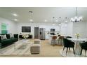 Open-concept living space featuring modern kitchen with stainless steel appliances and stylish dining area at 14957 Sw 63Rd Court Rd, Ocala, FL 34473