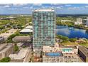 Stunning aerial view of a modern high-rise condo building, surrounded by city, lake and lush greenery at 150 E Robinson St # 2812, Orlando, FL 32801