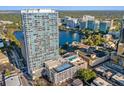 Aerial view of condo building overlooking a serene lake, cityscape, pool and tennis court at 150 E Robinson St # 3408, Orlando, FL 32801