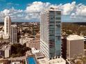 An aerial view of a condo building showcases downtown living with surrounding cityscape and blue sky at 150 E Robinson St # 3408, Orlando, FL 32801