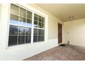 Covered entryway featuring a solid front door and brick style walkway plus large windows at 212 Regency St, Davenport, FL 33896