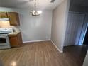 Dining area with wood-look floors and chandelier next to the kitchen at 2131 Cascades Blvd # 306, Kissimmee, FL 34741