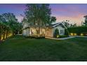 Beautifully landscaped home with lush green lawn, elegant shrubs, and tranquil twilight view at 2402.5 Temple Dr, Winter Park, FL 32789