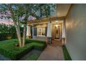 Inviting front porch with stone columns, manicured hedges, and stylish entryway at 2402.5 Temple Dr, Winter Park, FL 32789