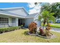 Close-up shot of a front yard featuring lush landscaping, a palm tree, and a well-maintained lawn at 2709 Prestwick Ln, Kissimmee, FL 34744