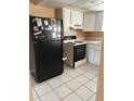 Practical kitchen space includes a black refrigerator, range, and tile flooring at 3040 Pinder Ct, Orlando, FL 32811