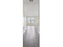 Bright hallway with neutral walls and tile flooring, leading to a window-lit room with a view of the outdoors at 3222 Sweet Acres Pl, St Cloud, FL 34772