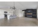 Open-concept living space with a modern fireplace, tile flooring, and kitchen island with barstool seating at 3222 Sweet Acres Pl, St Cloud, FL 34772