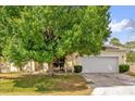 Residential house showing lawn, mature trees, and a two-car garage at 329 Alegriano Ct, Kissimmee, FL 34758