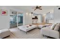 Open-concept living area with a modern coffee table, plush ottomans, and a view of the outdoor dining space at 334 Terrace Dr, Oviedo, FL 32765