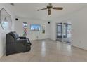 Spacious living area with tile flooring, a sleek TV, and a sliding glass door leading to the outdoors at 334 Terrace Dr, Oviedo, FL 32765