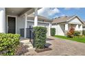 Home exterior featuring a brick driveway, neatly trimmed bushes, and a view of the front door and garage at 338 Wooded Vine Dr, Winter Springs, FL 32708