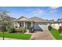 Charming single-story home featuring a brick driveway, covered porch, and well-manicured landscaping at 338 Wooded Vine Dr, Winter Springs, FL 32708