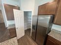 This kitchen features granite countertops, stainless steel appliances, brown cabinetry, and a pantry at 3408 Curlew Ave, Leesburg, FL 34748